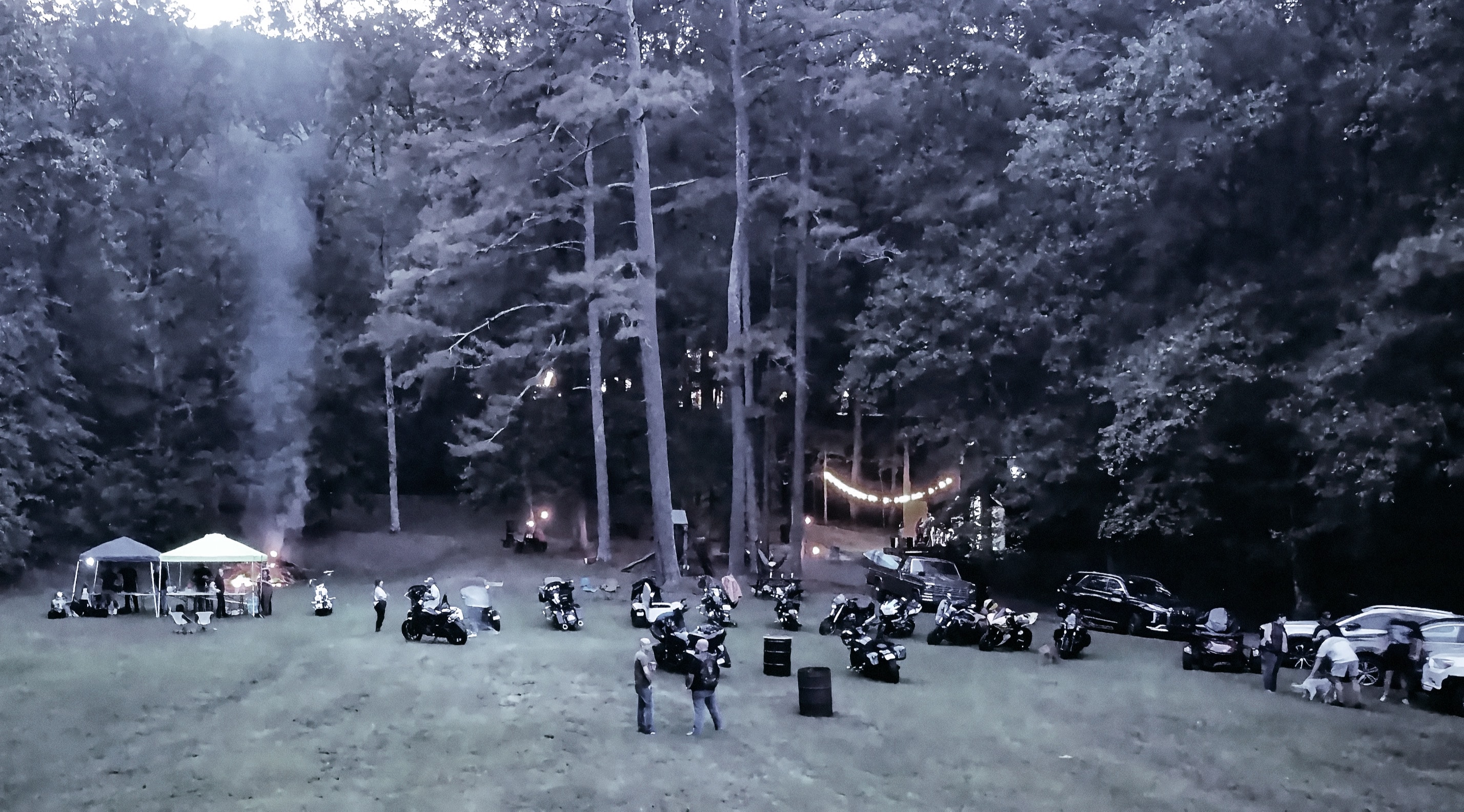 At Dug Hill — aerial view of motorcycles and campfire at dusk